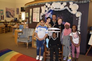 Children at Dr. King Elementary with rocking chair donated by UC
