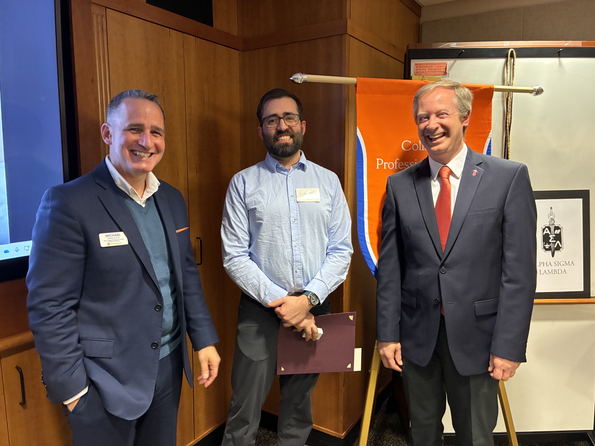 Dean Michael Frasciello and Senior Associate Dean Ryan O. Williams take a photo with a student. 